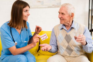 Cuidador ajudando idoso a separar medicamentos