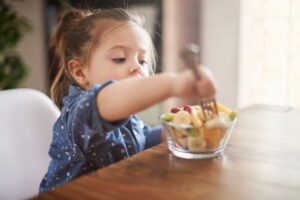 Criança consumindo alimentos saudáveis