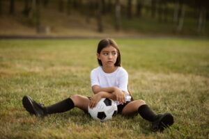 Criança triste após jogo de futebol