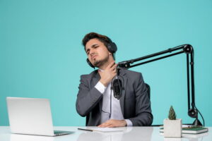 Pessoa falando ao microfone com dor na garganta