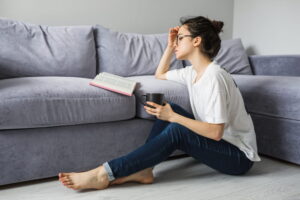 pessoa lendo livro no sofá com dor nas costas
