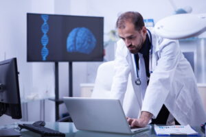 Neurocientista analisando imagens do cérebro em um computador.