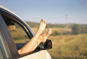pessoa com o pés pra cima no carro