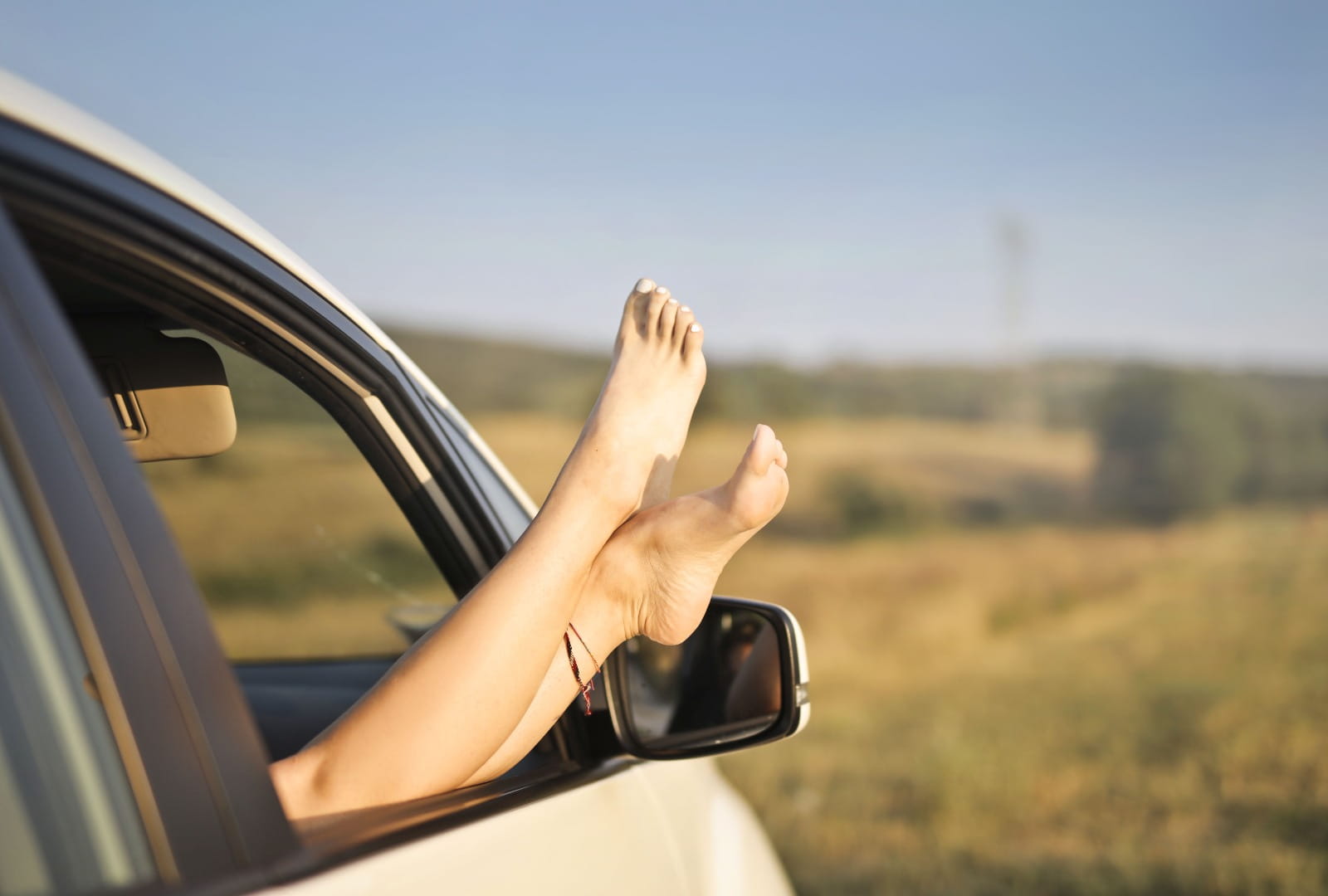 pessoa com o pés pra cima no carro