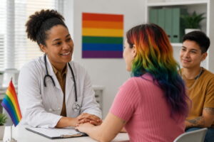Profissional de saúde conversando com paciente LGBTQIA+ em consultório