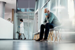 Homem adulto sentado em uma sala de espera médica