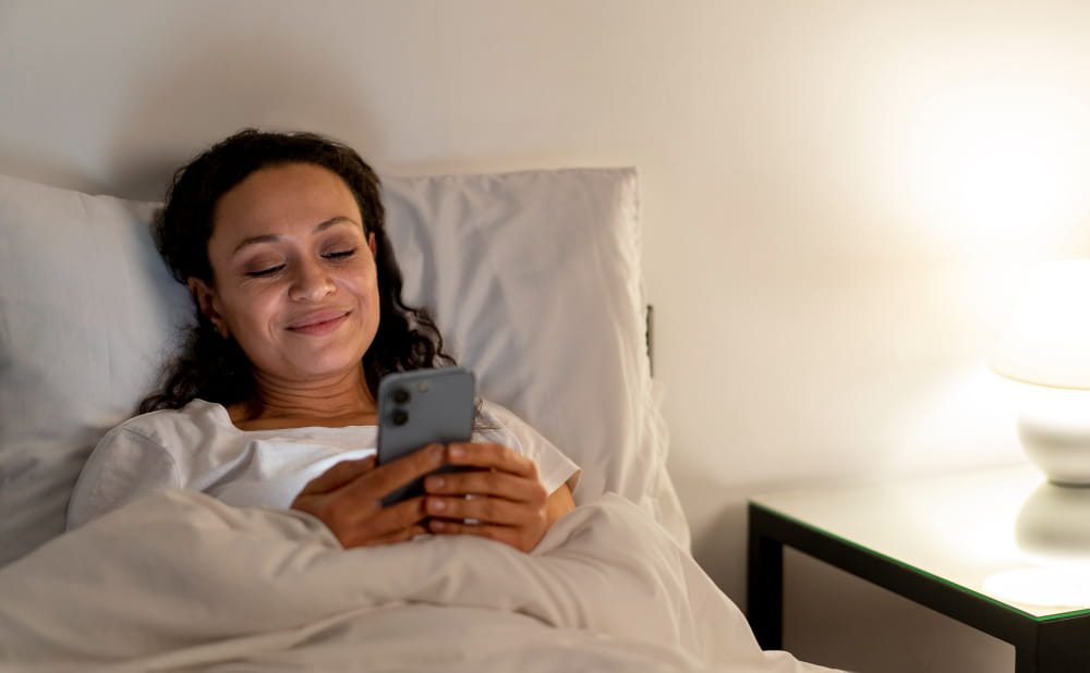 Celular na cama durante a noite.