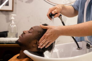Cabeleireiro lavando o cabelo do homem