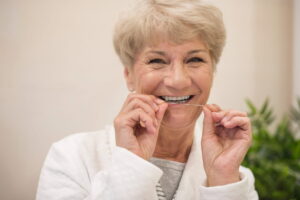 mulher madura usando fio dental