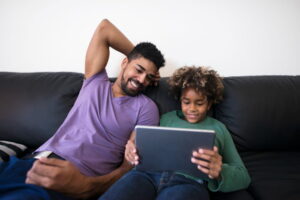criança com adulto supervisionando o tablet