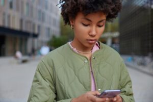 jovem usando celular na rua