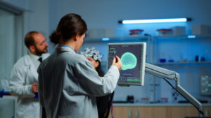 Imagem de um cérebro em laboratório, com pesquisadores analisando dados em telas.
